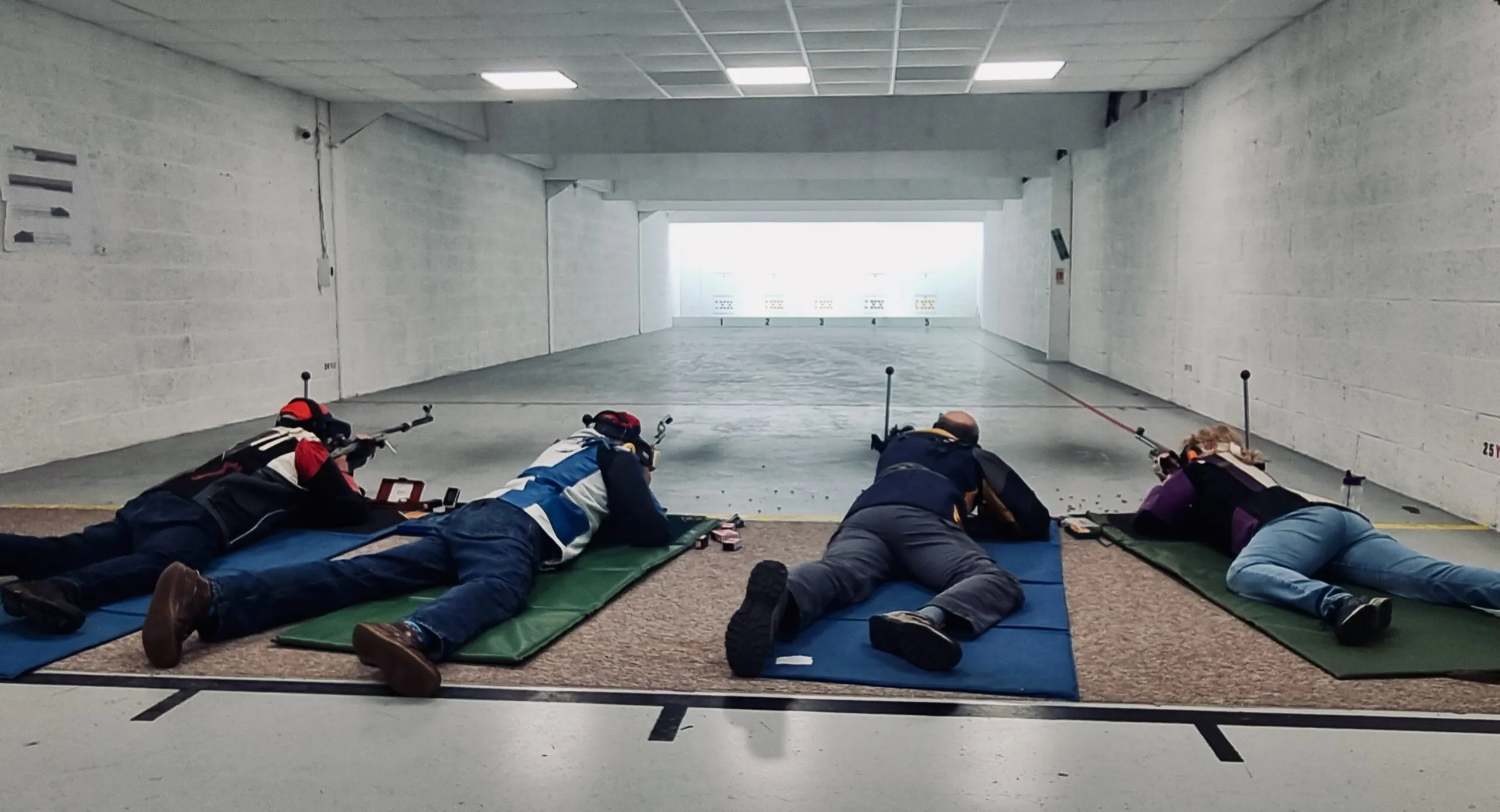 Shooters on the firing line at Pinhoe TSC's indoor 25-yard prone range.